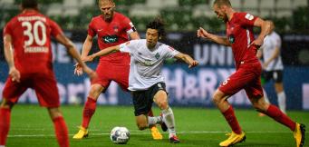 Bremens Osako im Kampf um den Ball gegen drei Heidenheimer.